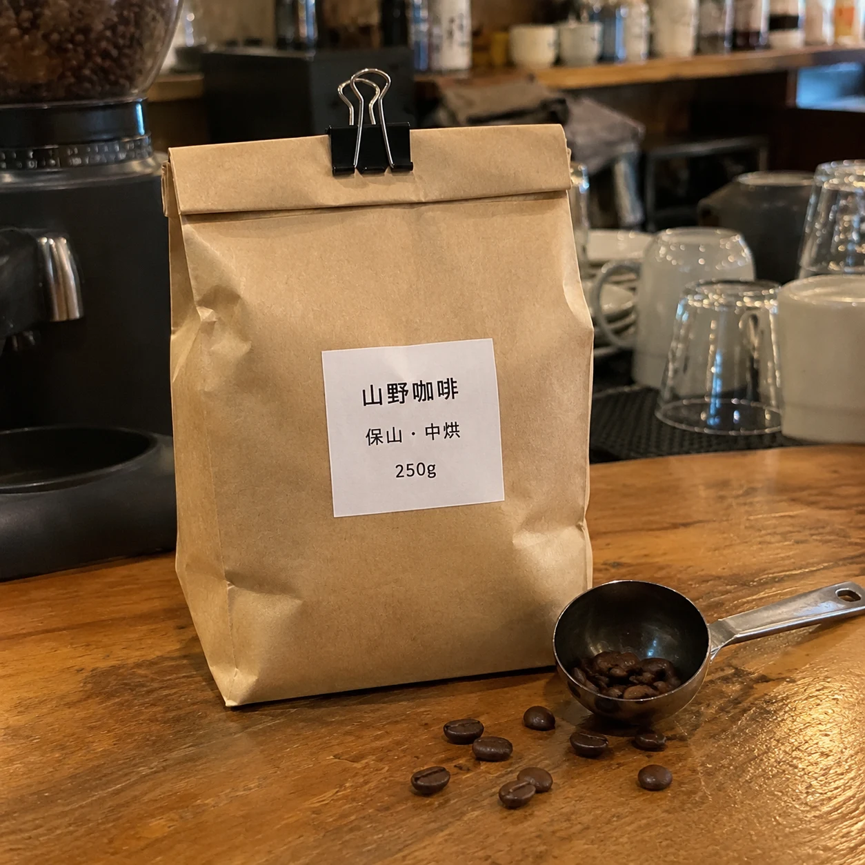 吧台上一袋牛皮纸咖啡豆，标签写着山野咖啡、保山 · 中烘、250g